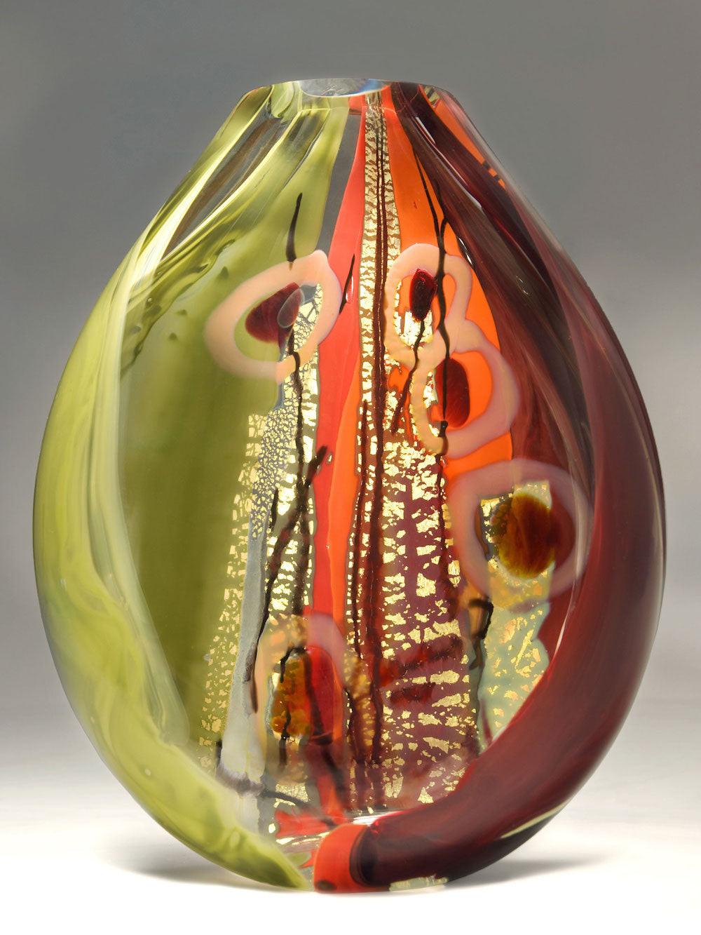 A blown glass vessel with intricate layers of gold, silver, and black. Contemporary Sculpture by a female artist.
