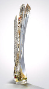 A tall hand blown glass sculpture features silver leaf and pops of red layered within thick clear glass.