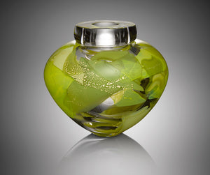 A thick clear hand blown glass vessel features five shades of green glass layered with gold leaf.